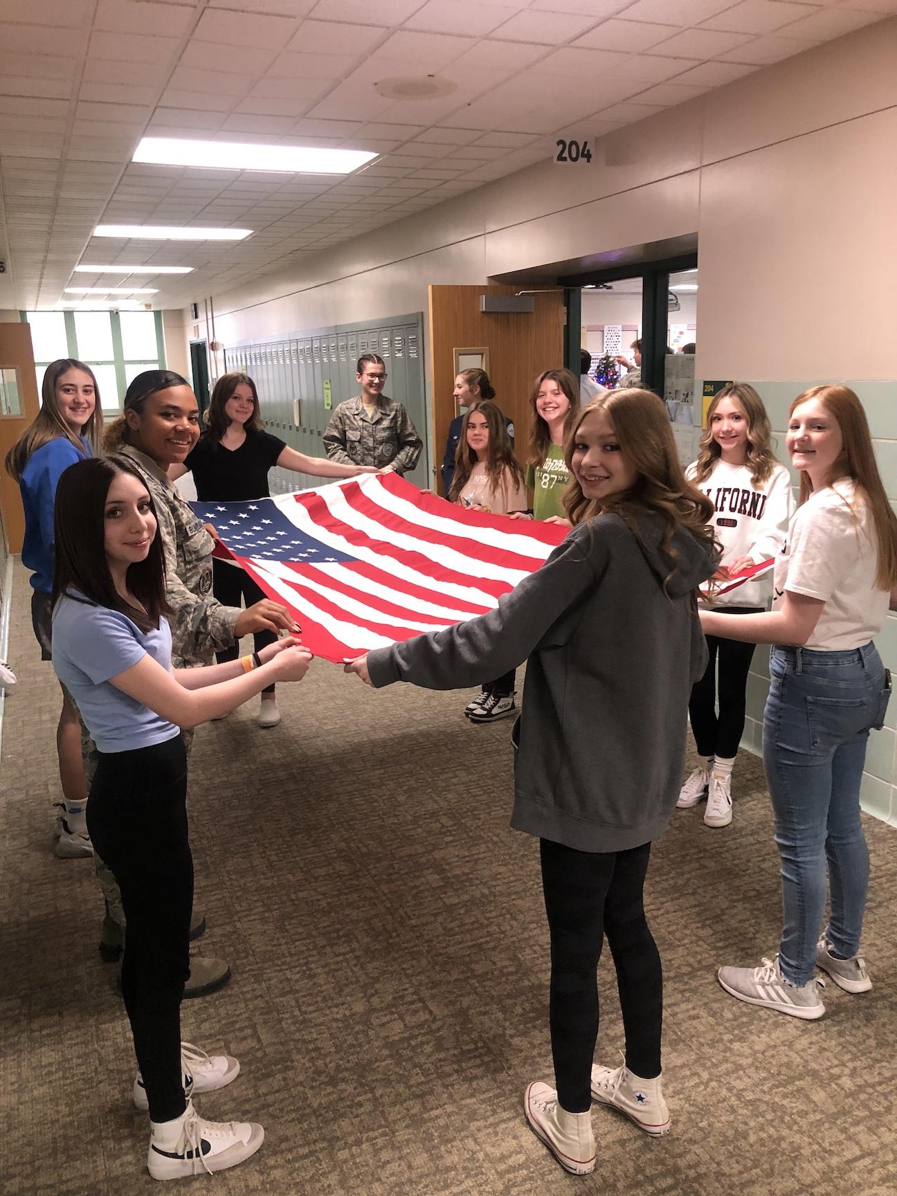 The students receive a lesson on flag handling and folding