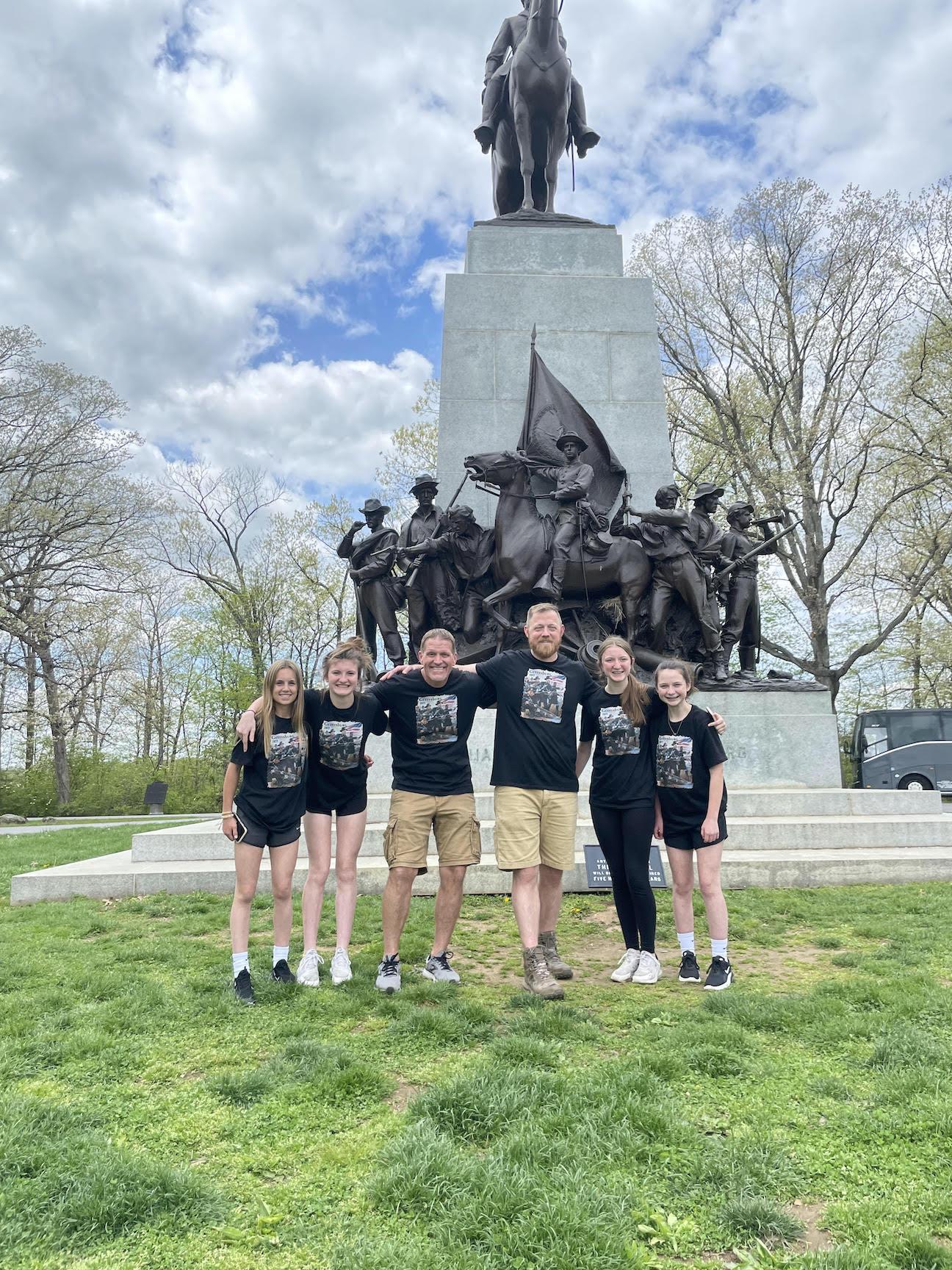 Ella Mains, Isabella Naglich, Mr. Waszo, Mr. Weir, Gabriella Naglich, and Amber Hackenberg pause for a photo at the Virginia Monument