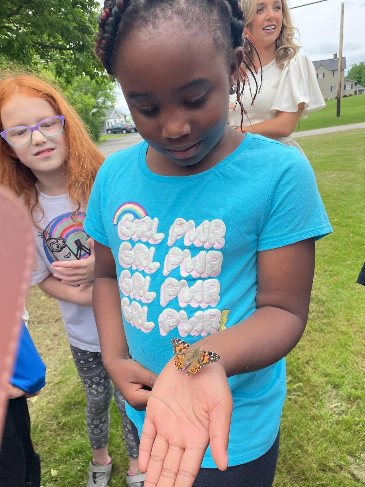 Chinonye Ulasi observes the butterfly resting on her palm
