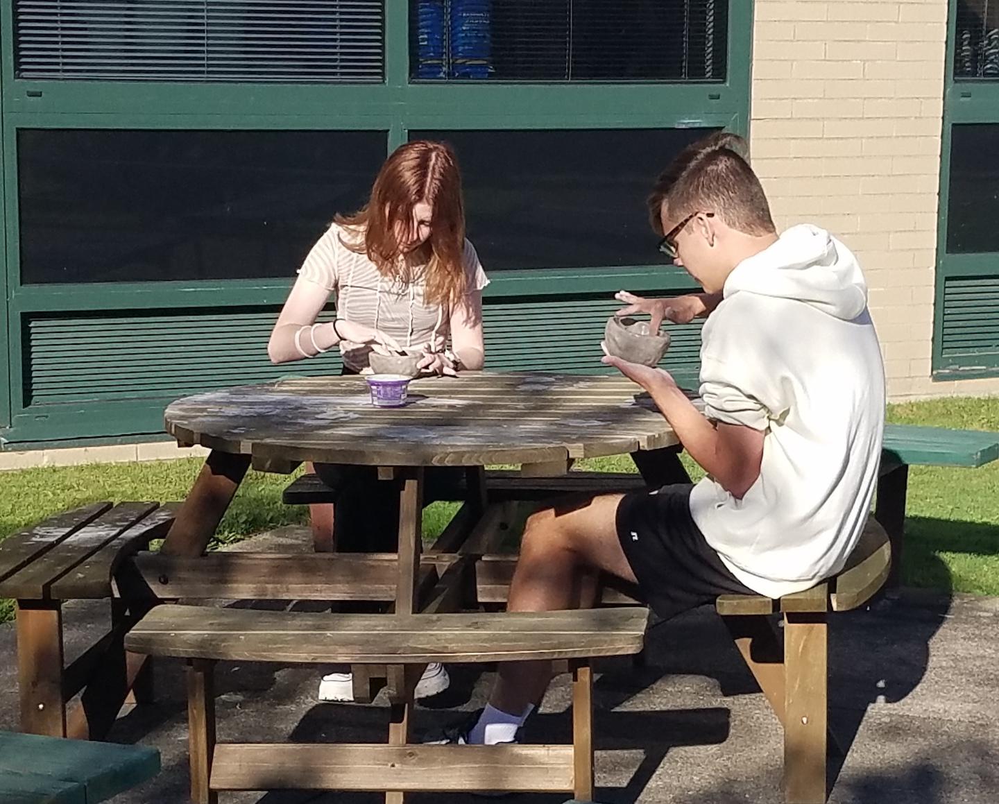 11th-graders Ruby Wright and Braeden Simon work on ceramics projects