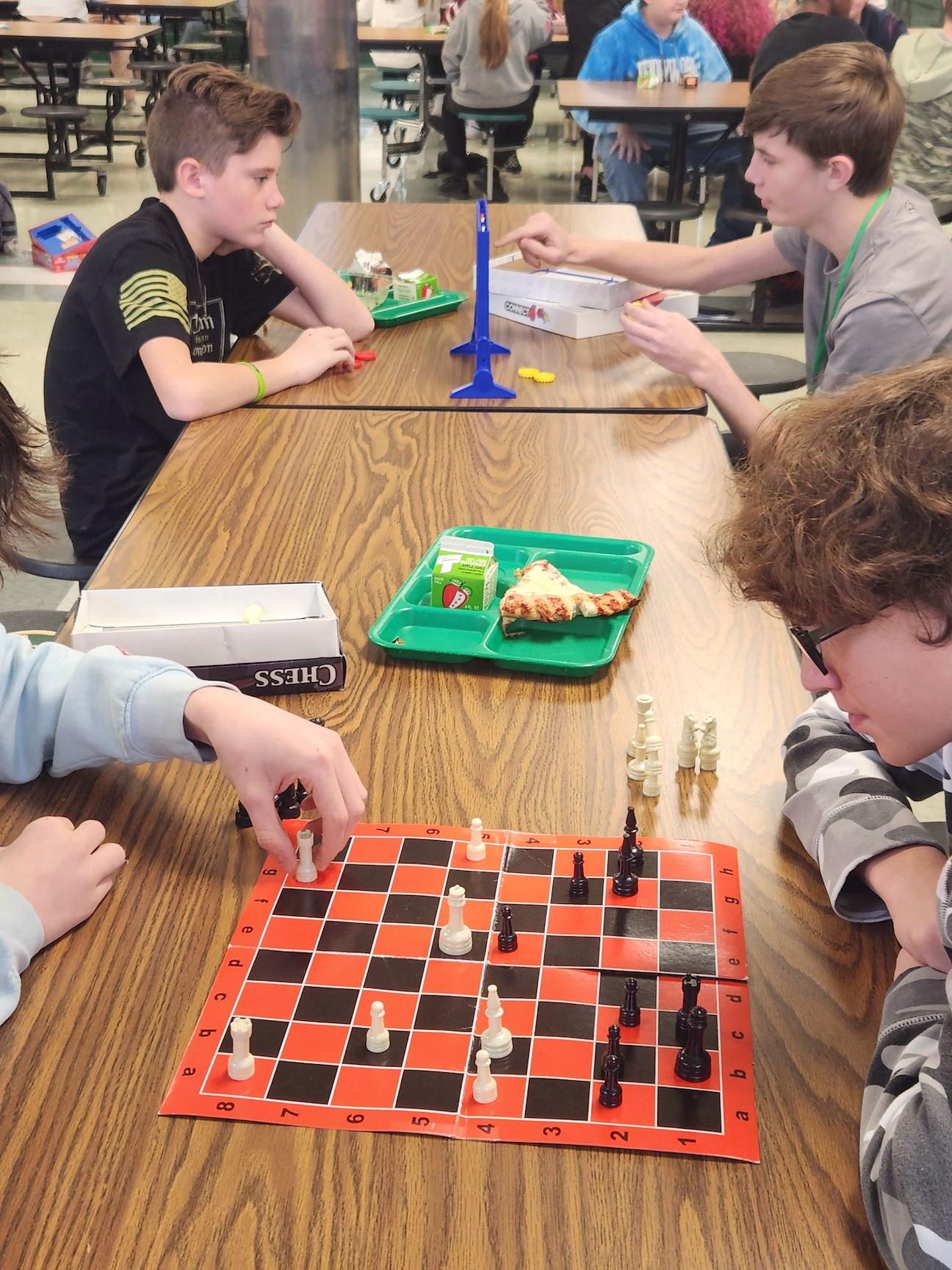 Brayden Tirpak and Noak Haslam compete at checkers, and in the background, Nino Sunseri and Grant Alexander enjoy Connect 4