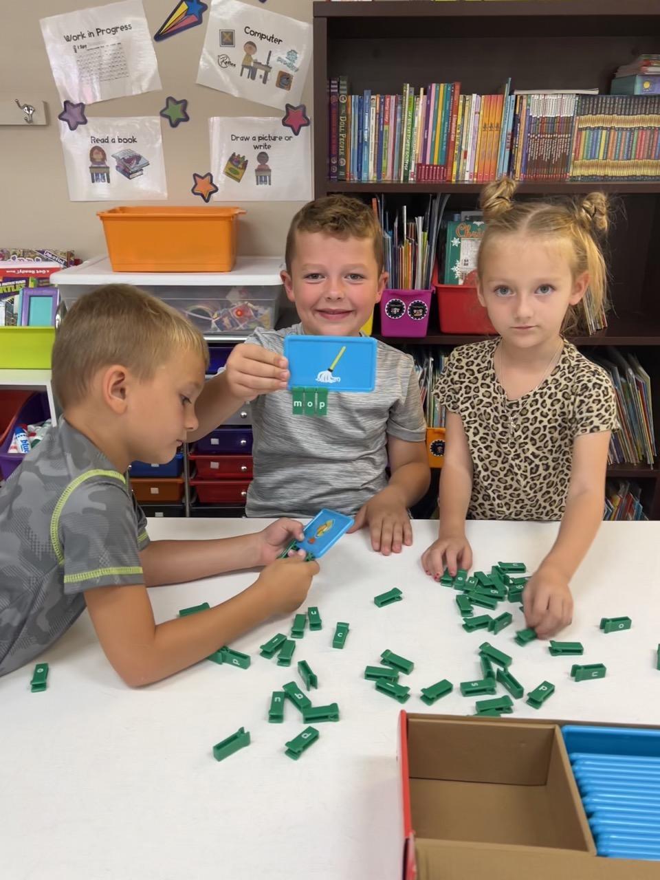 Adrian Zdrale, Wyatt Johnston and Ryann Dulemba work together using sound spelling cards