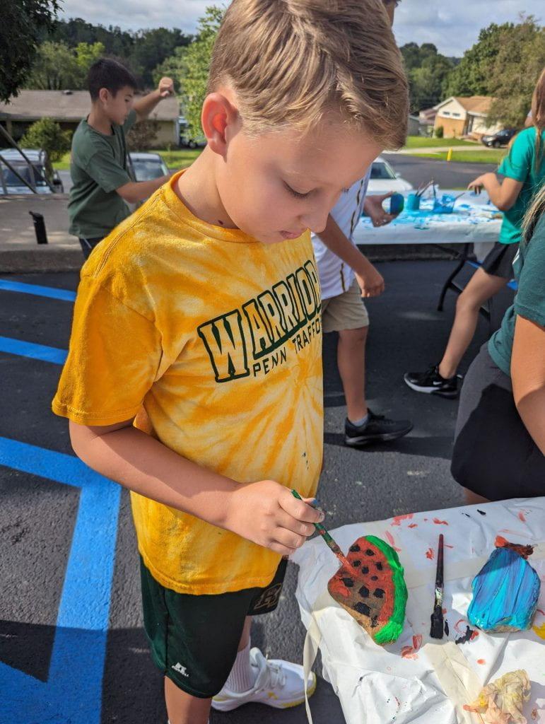 5th-grader Benjamin Tharp puts the finishing touches on his rock