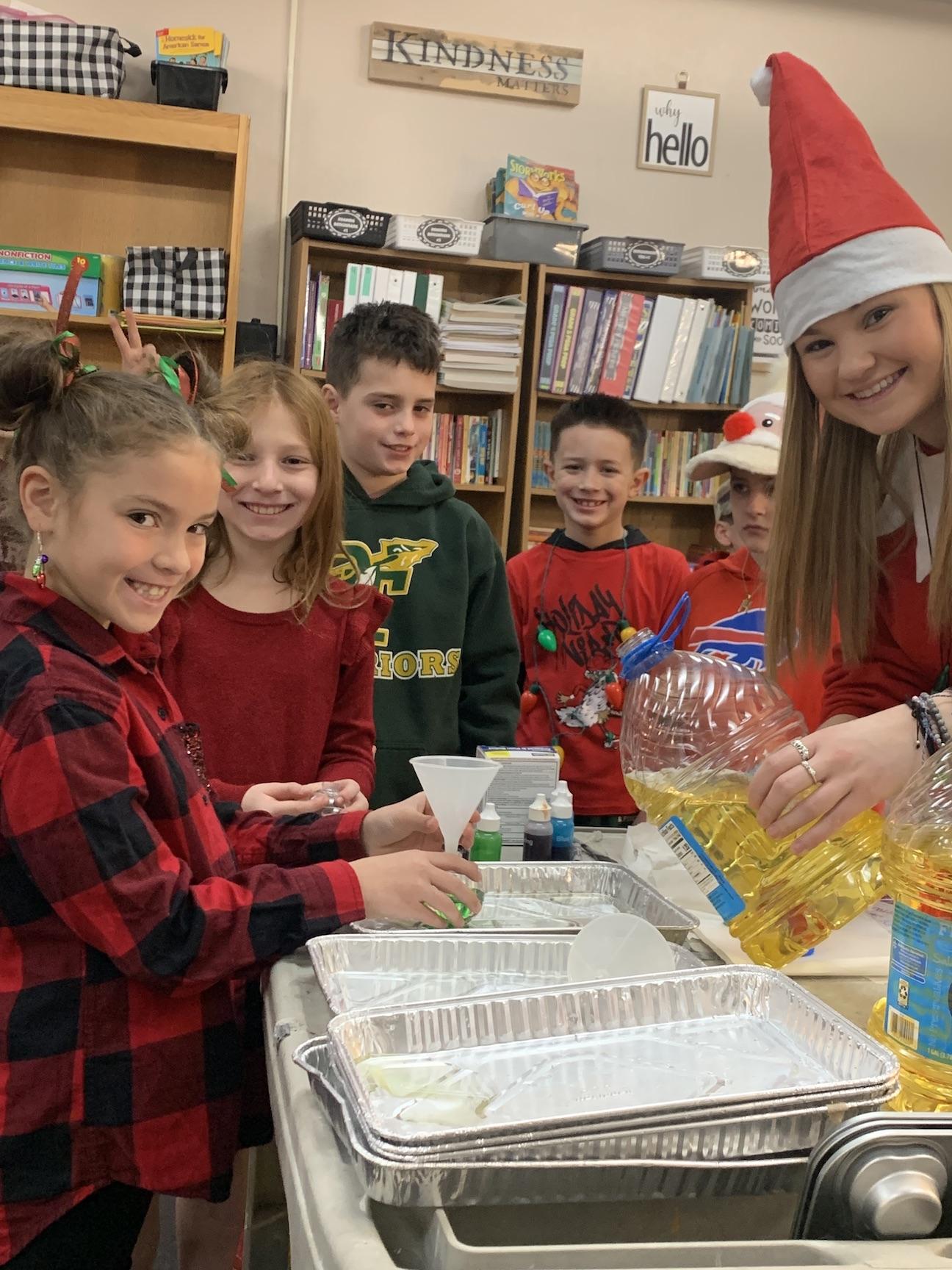 3rd-graders Willow Stack, Lily Sementuh, Gavin Dulemba, Lincoln Braun, Bobby McKillop and Miss Cipra get ready to start their ornaments