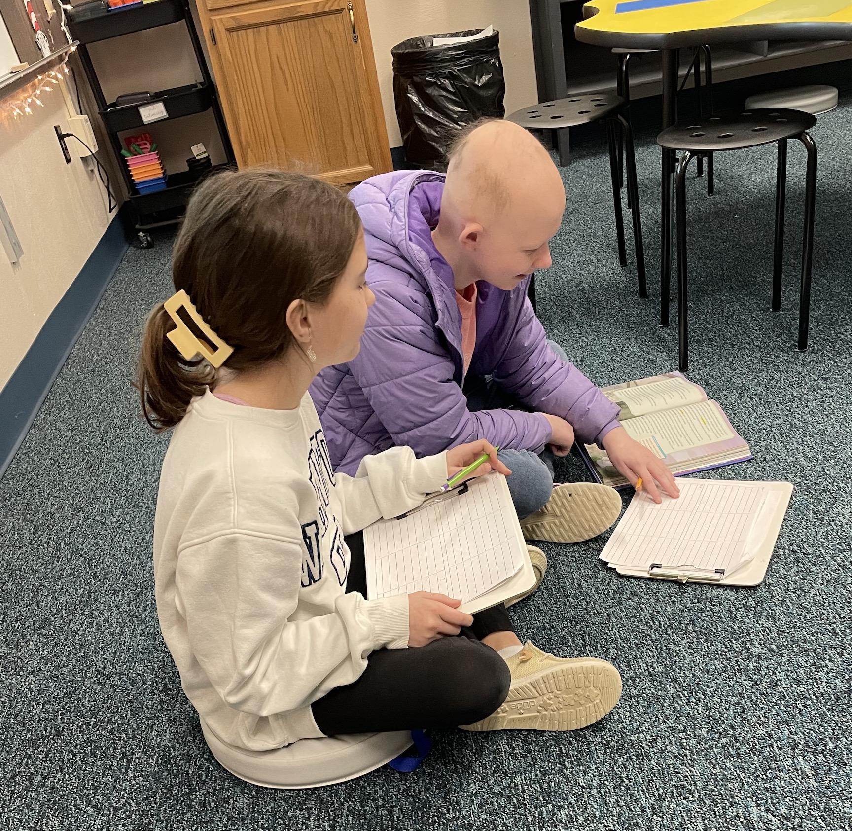 Fifth-graders Evalyn Borst and Emma Gligonic use the new floor cushions to complete an assignment