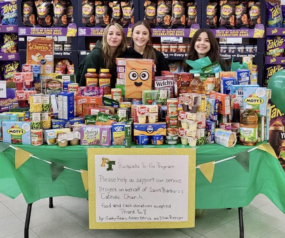 Jillian Rettger, Ashley Hetrick, and Gabby Geary display the food donations received