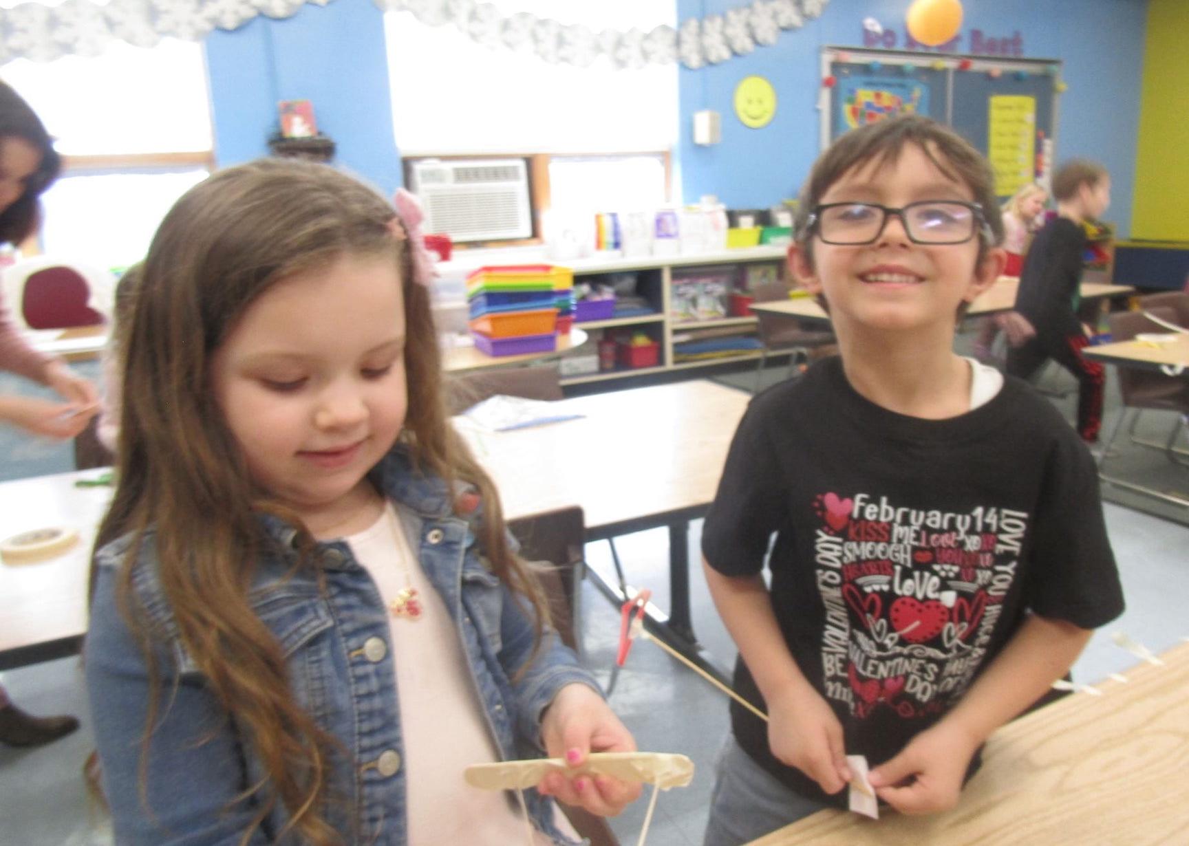 Kindergarteners Bella Lutz and Ikel Kroll create their bow and arrow
