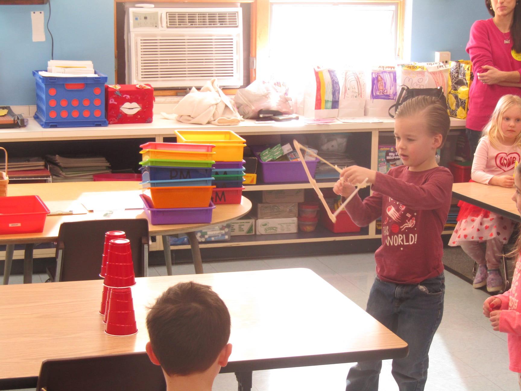 Kindergarten student Alex Karas practices with his bow and arrow 