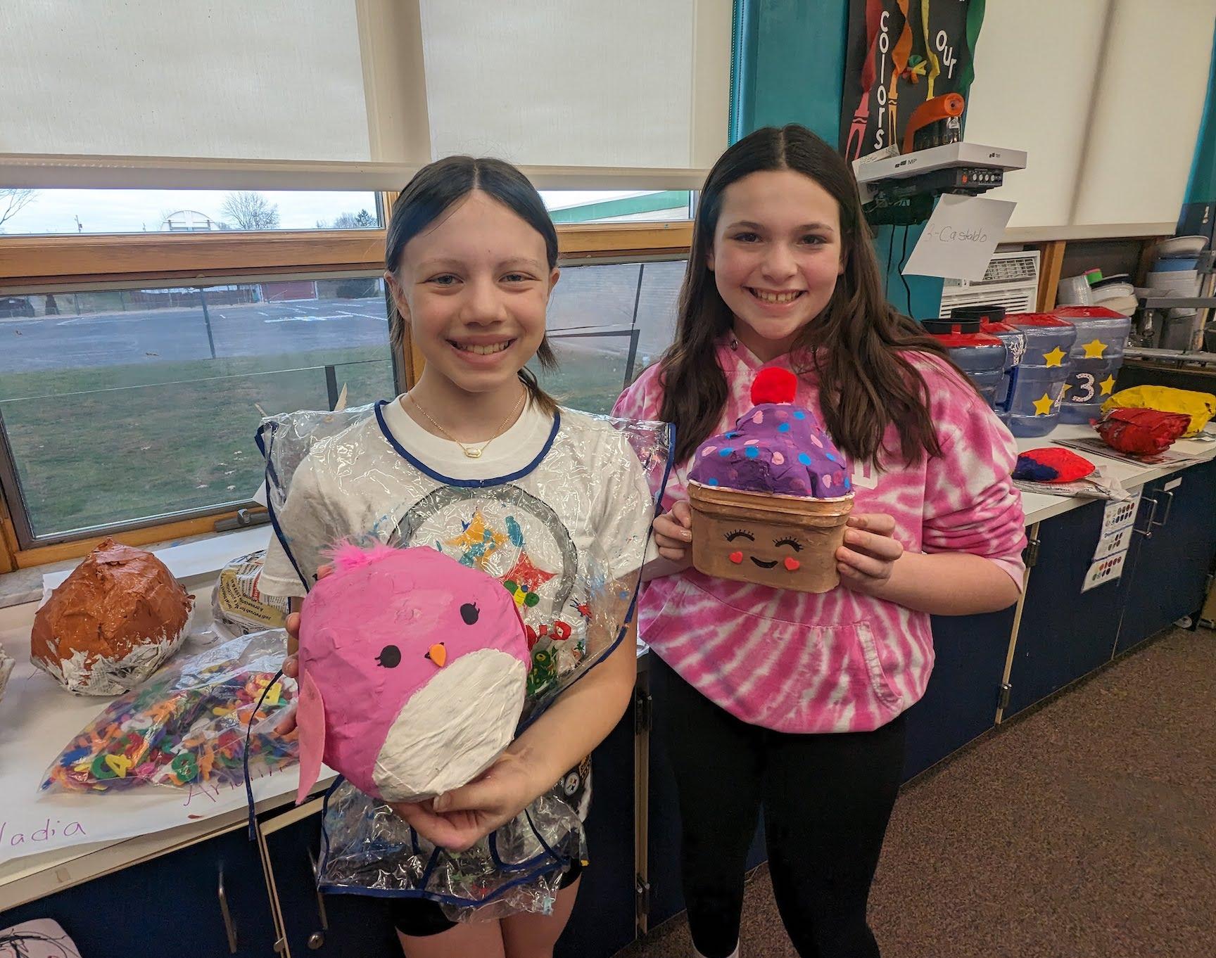 5th-graders Arianna Giardina and Delaney Flebotte hold theirs finished squishmallows