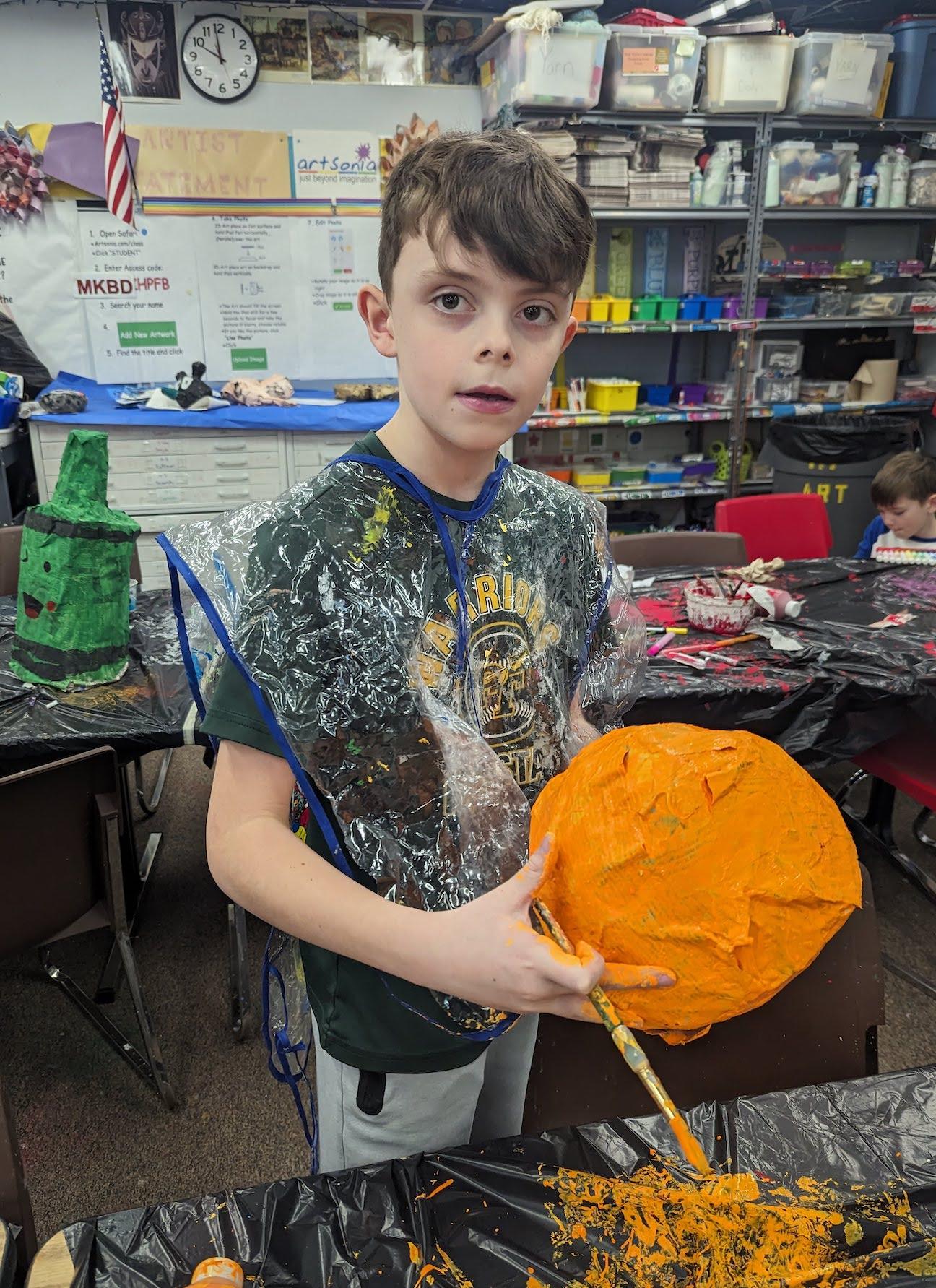 3rd-grader Eli Hodge paints his project