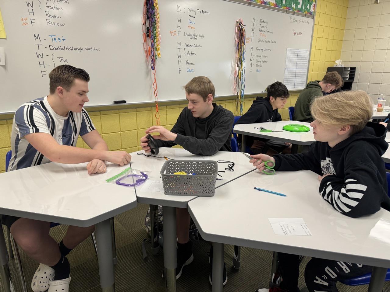 9th-graders Carson Weishorn, Collin Dransart and Jacob Binnion investigate the relationship between the circumference and diameter of a circle